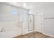 Bright bathroom featuring a walk-in shower with glass enclosure and separate soaking tub at 10158 W Angels Ln, Peoria, AZ 85383