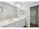 Bathroom featuring double sinks, white cabinetry, and a framed mirror at 10158 W Angels Ln, Peoria, AZ 85383