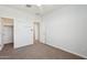 This bedroom has neutral colored carpet, a ceiling fan, and white walls at 10158 W Angels Ln, Peoria, AZ 85383