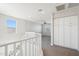Hallway with carpet, white cabinets, and white staircase with window and banister at 10158 W Angels Ln, Peoria, AZ 85383