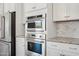 Stainless steel built-in oven, microwave, and refrigerator with marble-look backsplash at 10158 W Angels Ln, Peoria, AZ 85383