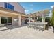 Covered outdoor living space with built-in bar, grill, wall mounted tv, and travertine flooring at 10158 W Angels Ln, Peoria, AZ 85383