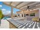 Covered outdoor living space with built-in bar, grill, ceiling fan, and travertine flooring at 10158 W Angels Ln, Peoria, AZ 85383