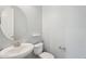 Simple powder room with elegant pedestal sink and a sleek round mirror at 10158 W Angels Ln, Peoria, AZ 85383