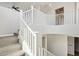 Staircase with white railings and carpeted steps, offering an open and airy design at 10158 W Angels Ln, Peoria, AZ 85383