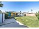 Large backyard with a well-kept lawn, a vibrant patio area, and a mix of colorful plants and landscaping at 1027 E El Camino Dr, Phoenix, AZ 85020