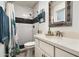Bright bathroom with white subway tile, a modern vanity, decorative mirror, and a walk-in shower at 1027 E El Camino Dr, Phoenix, AZ 85020