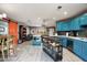 Bright, open kitchen featuring turquoise cabinets, a kitchen island, and stainless steel appliances at 1027 E El Camino Dr, Phoenix, AZ 85020