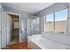 Inviting bathroom featuring a soaking tub, separate shower, and a large window at 10329 E Star Of The Desert Dr, Scottsdale, AZ 85255