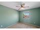 This cozy bedroom features neutral carpet, a ceiling fan, and a bright window at 10329 E Star Of The Desert Dr, Scottsdale, AZ 85255