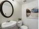 Well-lit powder room with a pedestal sink, oval mirror, and tasteful decor at 10329 E Star Of The Desert Dr, Scottsdale, AZ 85255