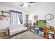 Well-lit bedroom with soft sofa, shelving unit, and a tv, creating a cozy and relaxing space at 10951 E Delta Ave, Mesa, AZ 85208
