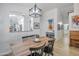 Contemporary dining room with modern lighting, blonde wood floors, and white walls with views of the kitchen at 10951 E Delta Ave, Mesa, AZ 85208