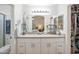 Main bathroom with double sinks, white cabinetry, neutral countertop, and access to closet at 10951 E Delta Ave, Mesa, AZ 85208