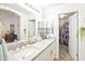 Main bathroom with double sinks, white cabinetry, neutral countertop, and access to closet at 10951 E Delta Ave, Mesa, AZ 85208