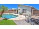 Private pool area with lounge chairs, artificial turf, a covered patio, and desert landscaping at 10951 E Delta Ave, Mesa, AZ 85208