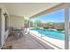 Inviting covered patio with views of a pool, palm trees, and artificial turf at 10951 E Delta Ave, Mesa, AZ 85208