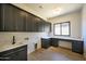 Well-equipped laundry room with ample cabinetry, counter space, sink, and a convenient workstation at 13290 E La Junta Rd, Scottsdale, AZ 85255