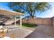 An inviting backyard features a patio area, a patch of green grass, and neutral-colored gravel for easy maintenance at 13585 N 87Th Dr, Peoria, AZ 85381