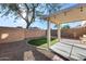 Relaxing backyard with a covered patio and a small, well-maintained patch of green grass surrounded by gravel at 13585 N 87Th Dr, Peoria, AZ 85381