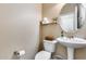 Stylish powder room with a pedestal sink, round mirror, modern fixtures and a shelf for storage at 13585 N 87Th Dr, Peoria, AZ 85381