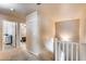Hallway featuring neutral carpeting, railing and open entryways leading into different rooms of the home at 13585 N 87Th Dr, Peoria, AZ 85381