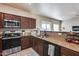 Well-equipped kitchen with dark wood cabinets and modern stainless steel appliances at 13585 N 87Th Dr, Peoria, AZ 85381
