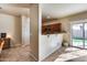 Open kitchen with brown cabinets, breakfast bar, and access to a sliding glass door for backyard views at 13585 N 87Th Dr, Peoria, AZ 85381