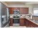Modern kitchen with stainless steel appliances and rich wood cabinetry at 13585 N 87Th Dr, Peoria, AZ 85381