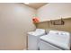 Functional laundry room with appliances, overhead shelving and lots of storage space at 13585 N 87Th Dr, Peoria, AZ 85381