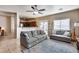 Inviting living room with comfortable gray couches, ceiling fan, and adjacent open-concept kitchen at 13585 N 87Th Dr, Peoria, AZ 85381