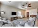 Open living room featuring a ceiling fan, wall-mounted TV, and tile flooring at 13585 N 87Th Dr, Peoria, AZ 85381