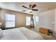 Bright main bedroom features a ceiling fan, multiple windows, and hardwood chest at 13585 N 87Th Dr, Peoria, AZ 85381
