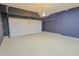Spacious garage with epoxy flooring, dark accent wall, and white garage door at 14850 E Grandview Dr # 138, Fountain Hills, AZ 85268