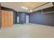 Spacious garage with epoxy flooring, storage cabinets, and a dark accent wall at 14850 E Grandview Dr # 138, Fountain Hills, AZ 85268