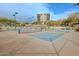 Several pickleball courts are ready for a match, set against a backdrop of desert landscaping and a condominium building at 14850 E Grandview Dr # 138, Fountain Hills, AZ 85268
