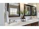 Bathroom featuring double sinks with granite countertops and decorative mirrors at 15105 W Glenrosa Ave, Goodyear, AZ 85395
