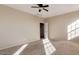 This bedroom features neutral walls and carpet, with a ceiling fan and an open doorway at 15105 W Glenrosa Ave, Goodyear, AZ 85395