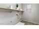 The laundry room is spacious, with shelving and a window for natural light at 15105 W Glenrosa Ave, Goodyear, AZ 85395