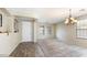 Open-concept living room featuring carpet and wood flooring and natural light with an elegant chandelier at 15105 W Glenrosa Ave, Goodyear, AZ 85395