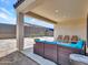 Covered patio area with comfortable seating, set in a backyard with gravel landscaping and block wall fencing at 15817 S 177Th Dr, Goodyear, AZ 85338
