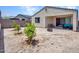 Home's backyard features a covered patio with stylish seating, a fire pit, and young trees adding natural beauty at 15817 S 177Th Dr, Goodyear, AZ 85338