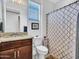 Cozy bathroom featuring granite counters, wood vanity, and a shower with patterned curtain at 15817 S 177Th Dr, Goodyear, AZ 85338
