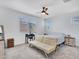 Bright bedroom with carpet features a ceiling fan, windows, desk, and a futon style couch at 15817 S 177Th Dr, Goodyear, AZ 85338