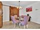 Dining area featuring a glass table with unique chairs, chandelier, and decorative barn door at 15817 S 177Th Dr, Goodyear, AZ 85338