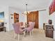 Elegant dining area with a glass table, purple chairs and a unique sliding barn door feature at 15817 S 177Th Dr, Goodyear, AZ 85338