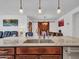 Modern kitchen island featuring a stainless steel sink, granite countertop, and decorative pendant lighting at 15817 S 177Th Dr, Goodyear, AZ 85338