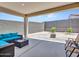 Covered patio with comfortable seating and an open backyard featuring desert landscaping and block fencing at 15817 S 177Th Dr, Goodyear, AZ 85338