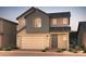 Charming two-story home showcasing neutral color palette, well-manicured landscaping, and an inviting brick pathway at 16442 W Whispering Wind Dr, Surprise, AZ 85387