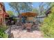 Inviting brick patio with outdoor dining area and shade umbrella under a beautiful tree at 1702 W Monterosa W St, Phoenix, AZ 85015